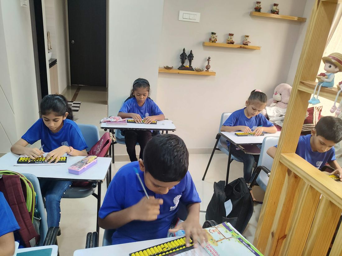 Children solving sums on the abacus during class